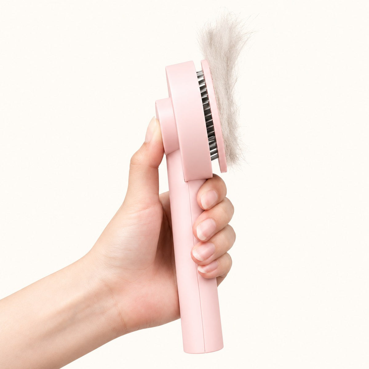 Pressing the pink brush button to lift collected fur