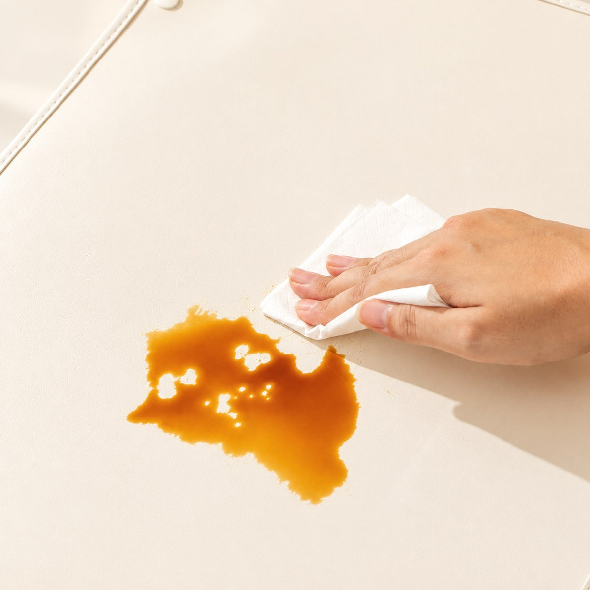 Wiping a spill from the cream PU feeding mat