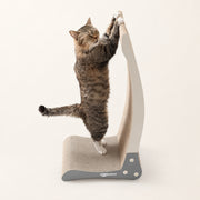 View image 2: Tabby cat making a full-body stretch on the Nookaroo Bennu vertical scratcher on a warm cream background