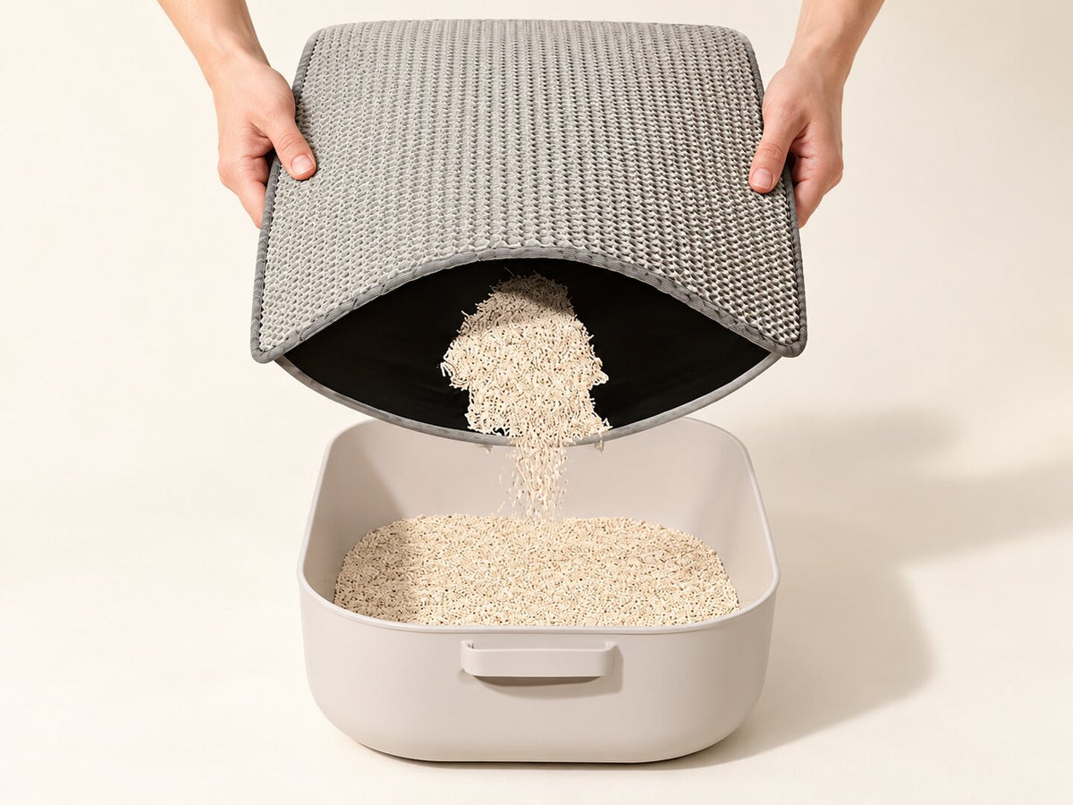 Hands tipping collected litter from the gray double-layer mat; tray not included — styled supplier image