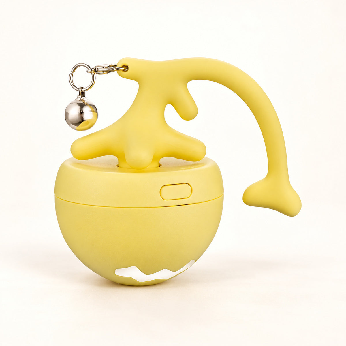Yellow Orbit rechargeable cat ball with its curved topper and silver bell on a warm ivory background