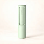 View image 1: Mint-green reusable pet hair remover in its self-cleaning case on a warm ivory background